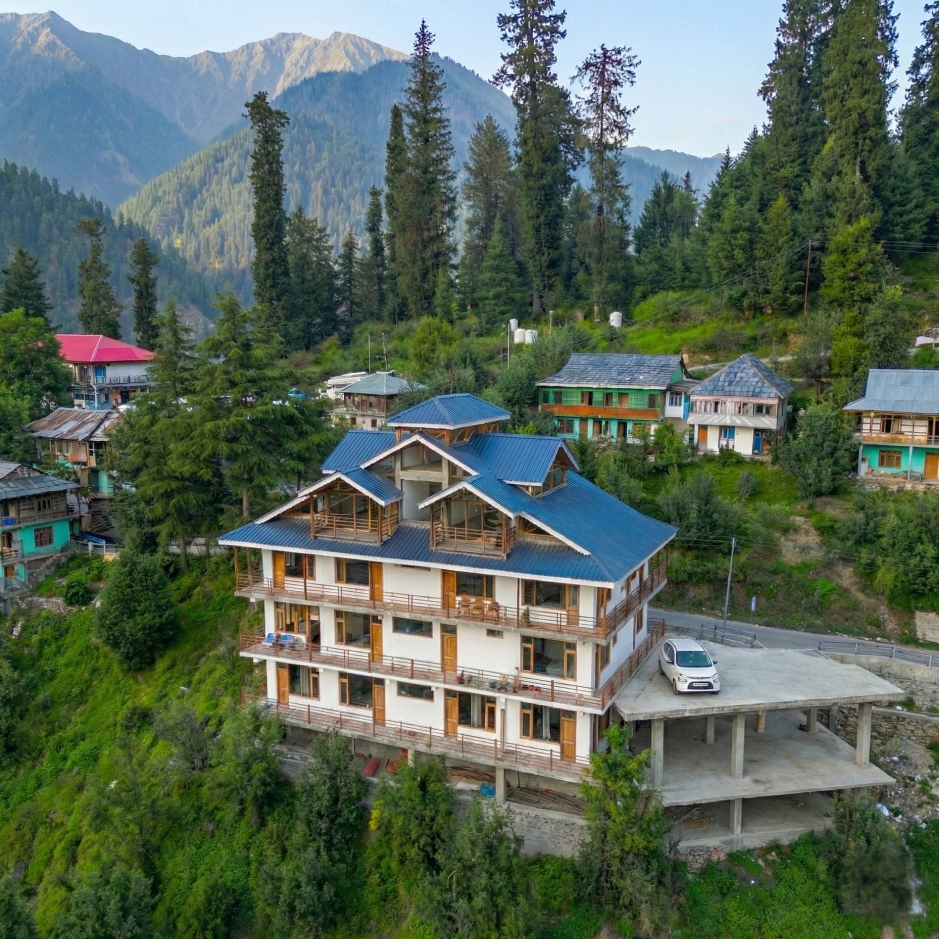 NestoStay seen from the path below, forest behind it, Shoja